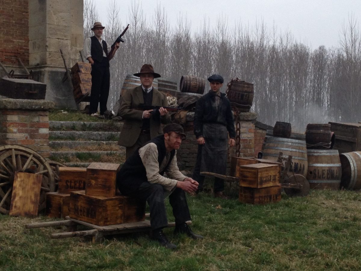Period scene with barrels and armed men on an outdoor set