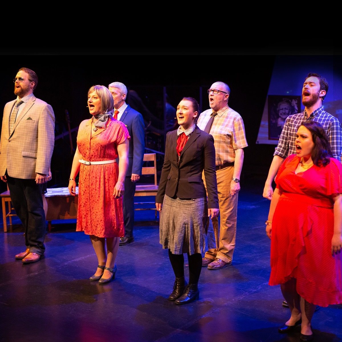 Ensemble cast singing on stage
